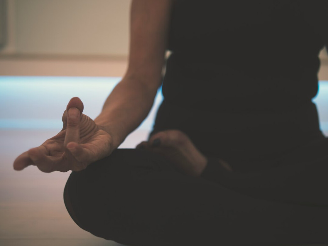 Woman sitting calmly with eyes closed in a bright room