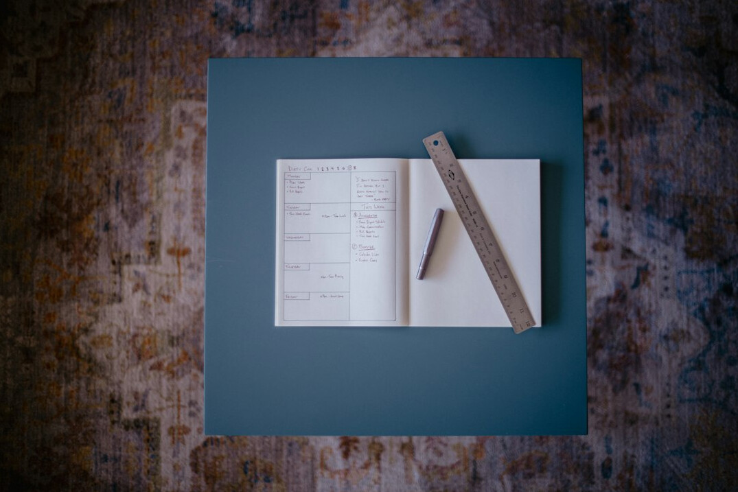 Open notebook with pen on a wooden desk